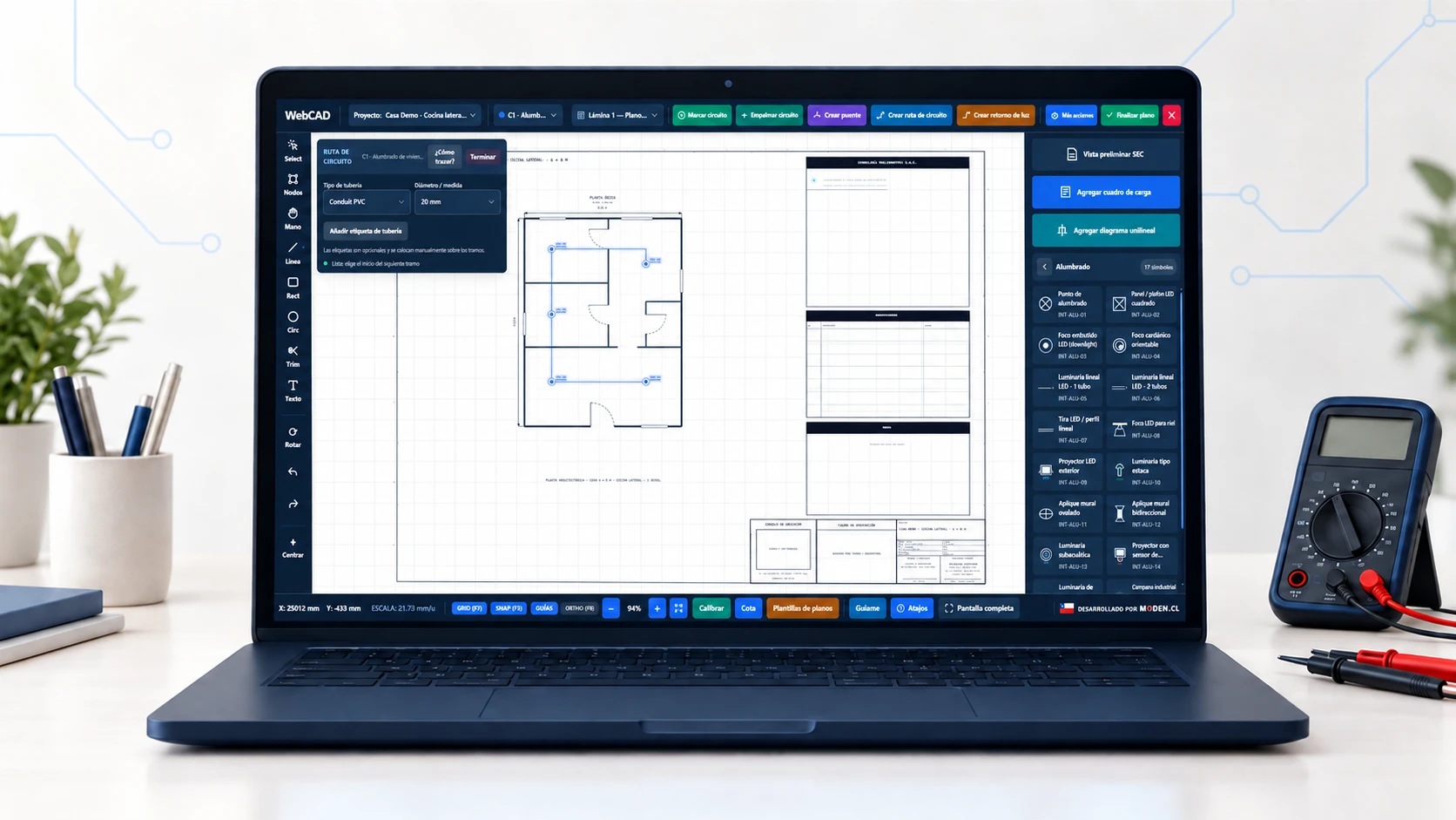 Mockup Oficial: WebCAD Studio en laptop sobre escritorio de ingeniería con plano eléctrico, simbología SEC y multímetro digital.